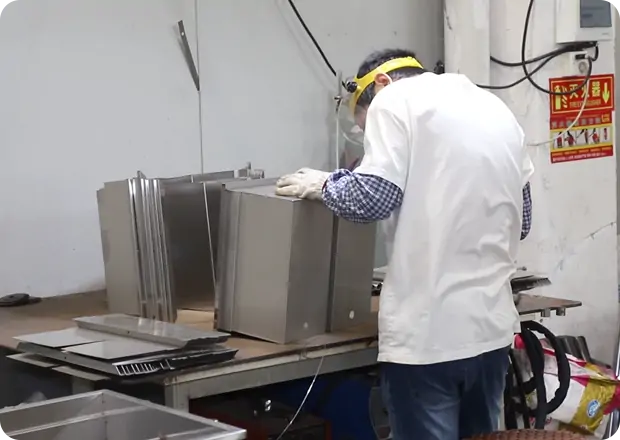 Skilled welding specialists fabricating stainless steel commercial deep fryer structures